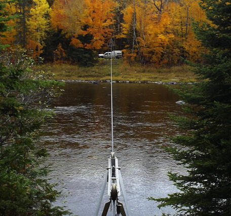 Survey equipment next to a river in the fall.