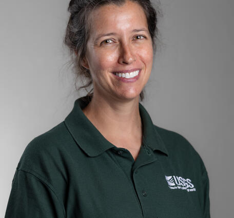 A woman in a green shirt smiling for her picture.