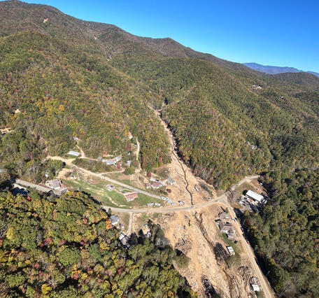 aerial view of stream flowing through a landslide runout path