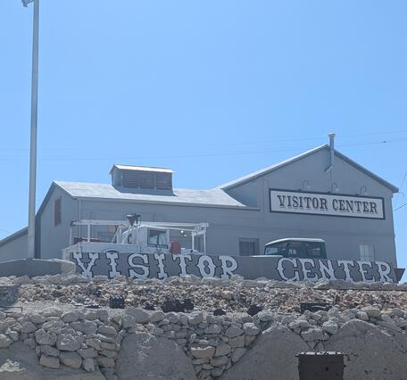 Photo of the Tonopah Historic Mining Park Visitor Center; gray building against bright blue sky.