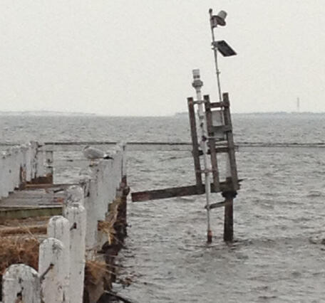 Looking out along a damaged pier at a wooden tower barely held upright by the scientific equipment it housed before the storm