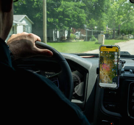 Person driving while looking at smart phone app