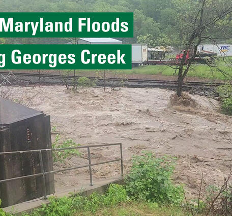 A flooded Georges Creek with an adjacent USGS streamgage. Text reads: Western Maryland Floods. Surveying Georges Creek