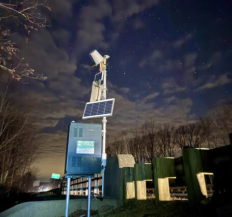 Photo of a U.S. Geological streamgage with solar panels added to help charge battery due to low light in the winter.
