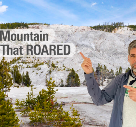 Main pointing to a barren mountainside with steam vents