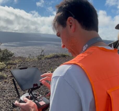 Color photo of USGS scientist and National Parks Service staff looking at the UAS operation screen. 