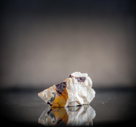 Isolated USGS mineral specimen featuring almandite garnet and calcite.