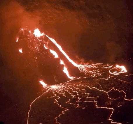 Lava bubbling out of a fissure at night time.