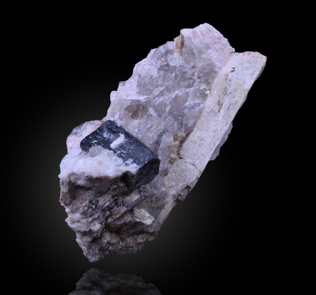 Gray/white/black stone in front of a black background, lithium in pegmatite with tantalum from the Carolinas.