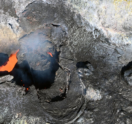 Color photograph of volcanic vent with lava inside