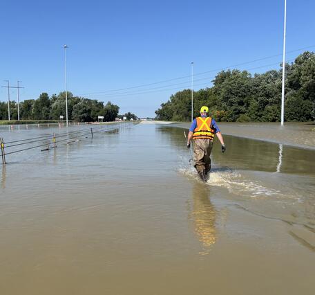 USGS hydrologic technician wading on Interstate 70