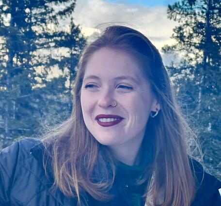 Woman smiling with trees in the background