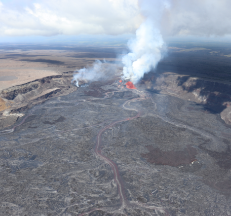Aerial view of a lava fountain erupting in a crater and feeding several streams of lava across the crater floor