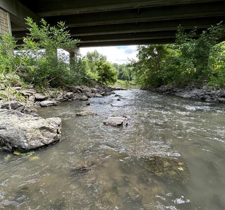 View of stream under highway overpass