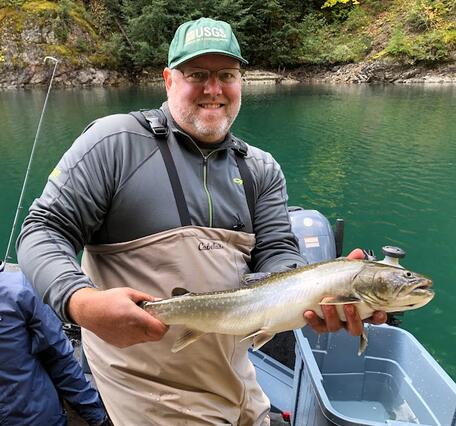 scientist holding fish on boat