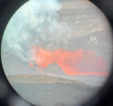 Color photograph of eruption through a lens