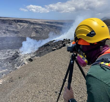 Color photograph of scientist on volcanic crater rim