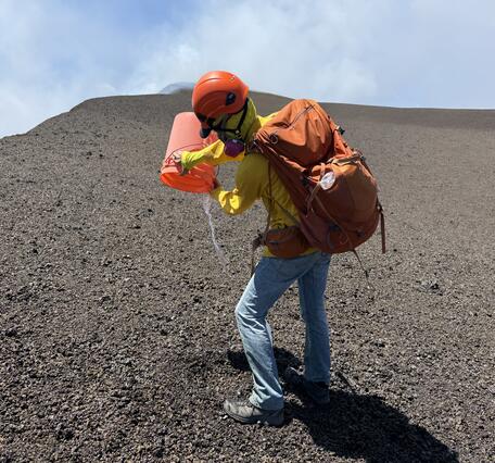 Color photograph of scientist emptying a bucket