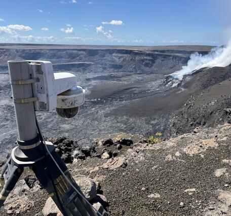 Color photograph of volcano monitoring webcam overlooking volcanic crater with degassing vent