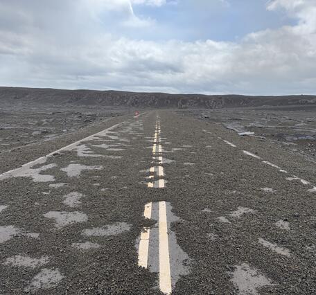Color photograph of road covered with tephra