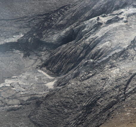 Color photo of cooled, black lava that overflowed from the north vent. 