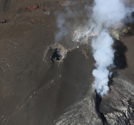 color photo looking down at what look like two small holes in the rock that are the north and south vents.