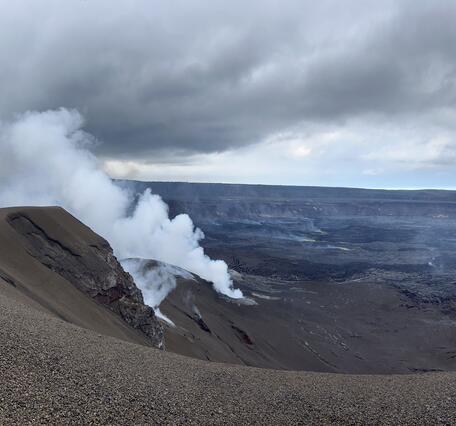 Color photograph of steaming volcanic crater
