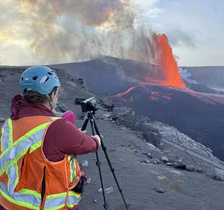 Color photograph of scientist monitoring volcanic eruption