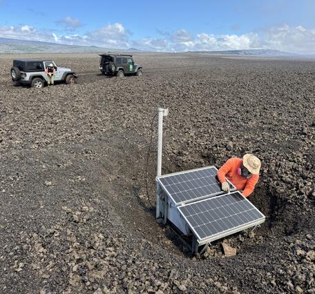 Color photograph of person fixing monitoring station