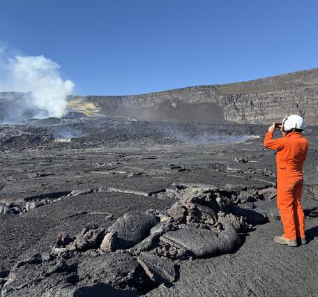 Color photograph of scientist documenting a volcanic vent