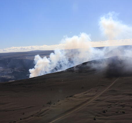 Color photograph of volcanic hill that is degassing
