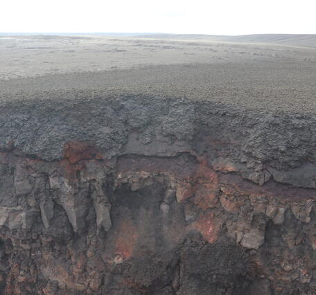 Color photograph of cliff exposing volcanic deposits