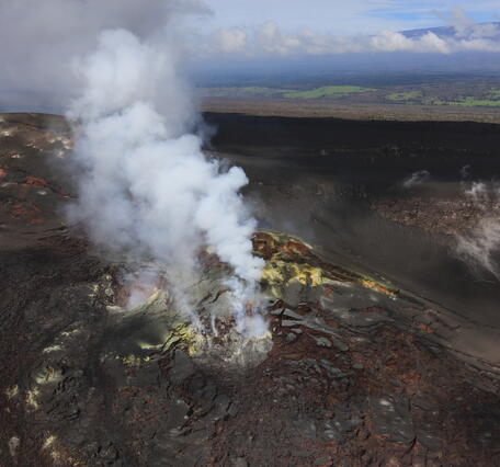 Color photograph of degassing vents with sulphur deposits nearby