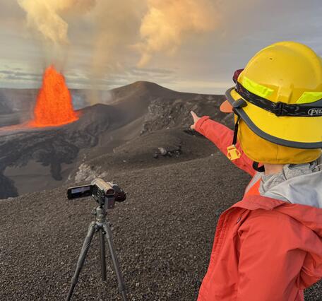 Color photograph of scientist monitoring volcanic eruption