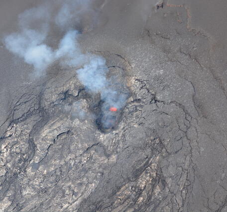 Color photograph looking down into an active volcanic vent