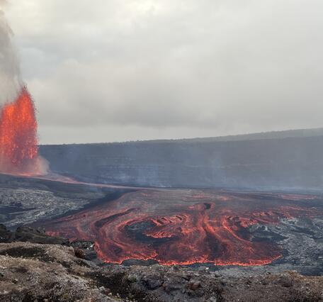 Color photograph of lava fountain and lava flow within crater