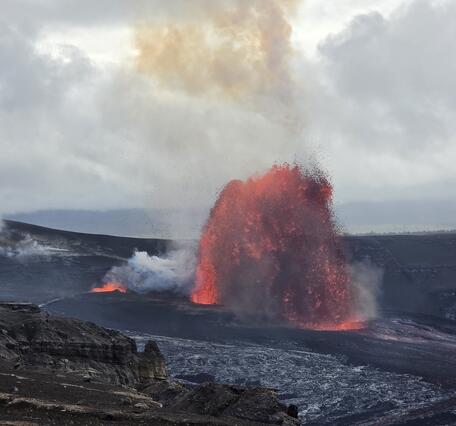 Color photograph of lava fountain with smaller spattering nearby
