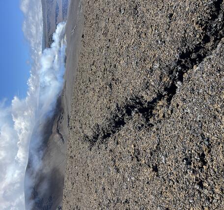Color photograph of volcanic deposit with crack in the ground