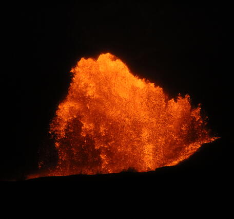 Color photograph of lava fountain at night