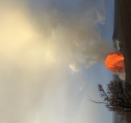 Color photograph of lava fountain in the distance