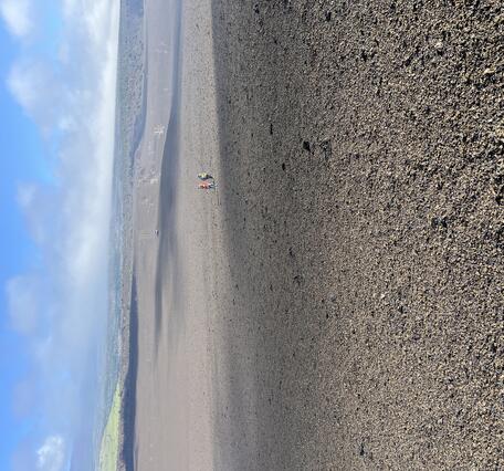 Color photograph of volcanic landscape with people in the background