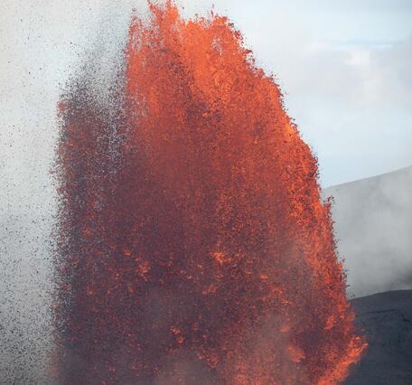 Color photograph of lava fountain erupting during the day