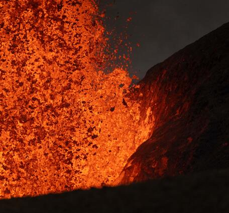 Color photograph of lava fountain base next to cone at night