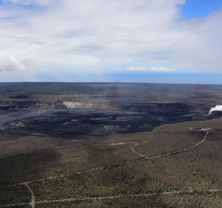 Color photograph of volcanic caldera with degassing vent