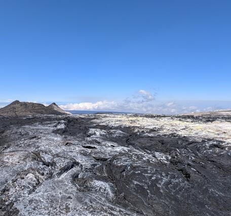 Color photograph of volcanic vent with sulfur deposits surrounding it