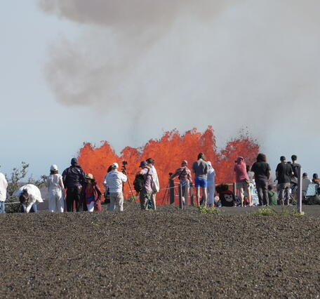 Color photograph of crowds watching lava fountain