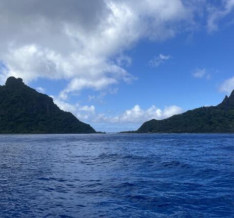 Color photograph of ocean in foreground, island in background