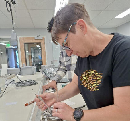 Scientist in a lab collecting samples from an open sediment core