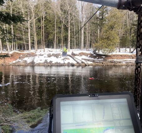 Hydrologic technician takes acoustic Doppler current profiler streamflow measurement from the center of a river via cableway