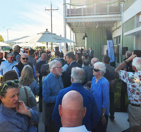 After the ceremony, attendees gather outside the new Tech Park facility to celebrate its grand opening. 